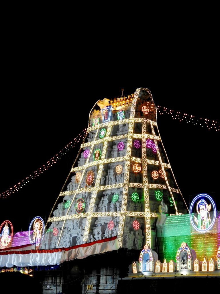 Vibrant night view of the illuminated Tirumala Temple adorned with festive lights.